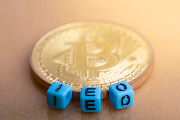 Gold coin with bitcoin symbol and dice spelling IEO.