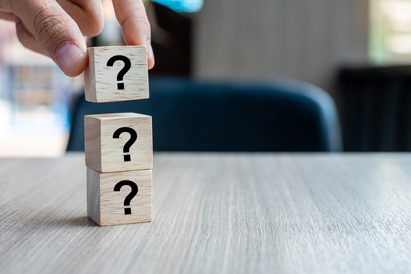 Stacked wooden blocks with question marks on them.