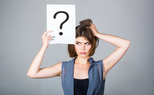 Woman holding a sign with a question mark on it.