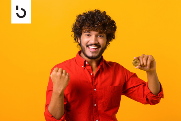 man holding a coin with bitcoin symbol