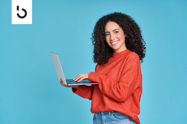 smiling woman holding a laptop